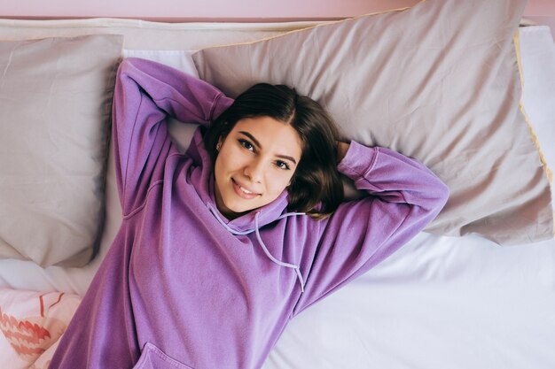 Jonge kalme blanke vrouw ontspannen liggend op een comfortabel bed in de ochtend, luie gelukkige vrouw thuis rusten.