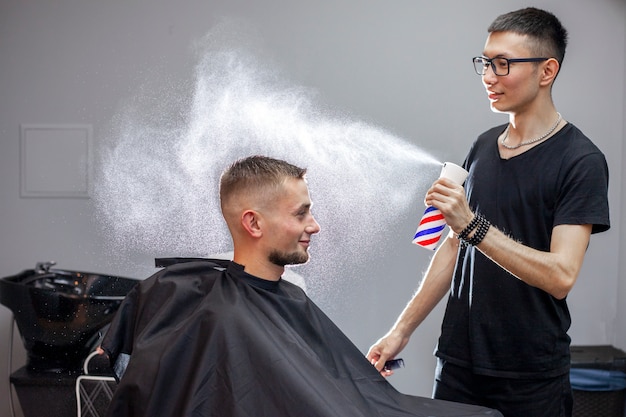 Jonge kapper werkt in een kapsalon