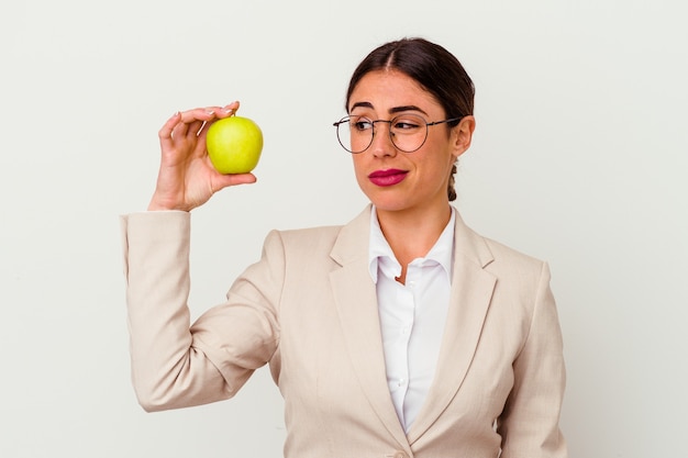 Jonge kaukasische bedrijfsvrouw die een geïsoleerde appel eet