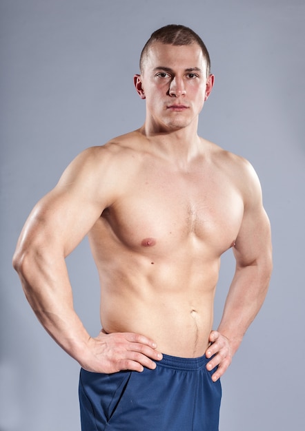 Jonge Kaukasische bodybuilder op blauw