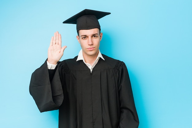 Jonge Kaukasische gediplomeerde mens die zich met uitgestrekte hand bevindt die eindeteken toont