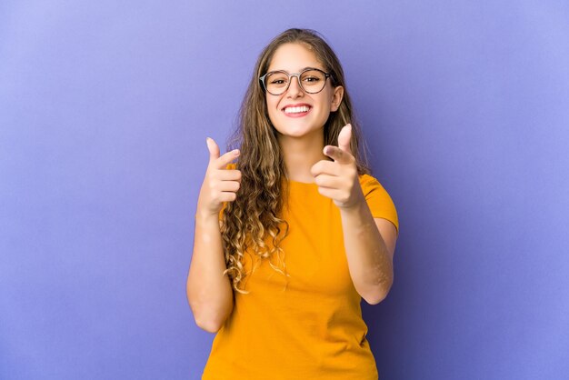 Jonge kaukasische leuke vrouw die naar voorzijde met vingers richt.