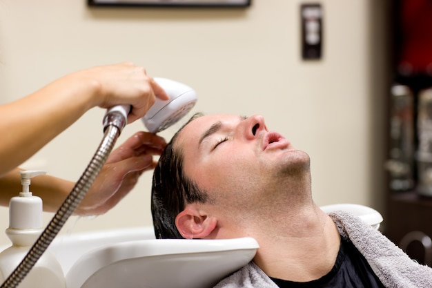 Jonge Kaukasische mens die zijn gewassen haar heeft