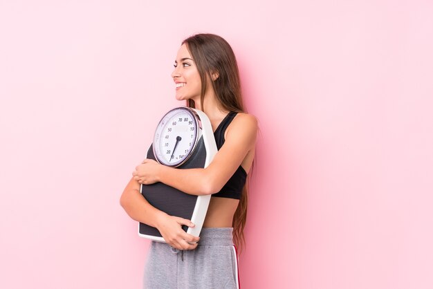 Jonge Kaukasische sportieve vrouw die een schaal houdt