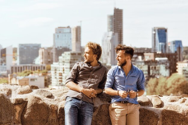 Jonge kaukasische vrienden kijken naar de afstand in de skyline van de stad als concept voor reizen en vriendschap