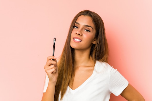 Jonge Kaukasische vrouw die een eyebrush houdt