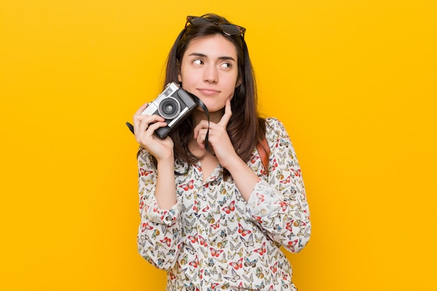 Jonge kaukasische vrouw die een uitstekende camera houdt