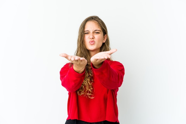 Jonge kaukasische vrouw die lippen vouwt en palmen houdt om luchtkus te verzenden.