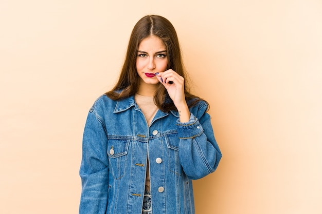 Jonge kaukasische vrouw die met vingers op lippen een geheim houdt.