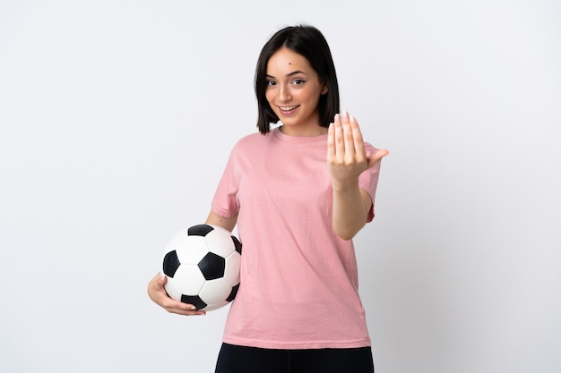 Jonge kaukasische vrouw die met voetbal wordt geïsoleerd en komend gebaar doet