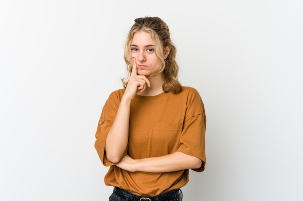 Jonge kaukasische vrouw die op witte achtergrond overweegt, een strategie plant, nadenkt over de manier van een bedrijf.