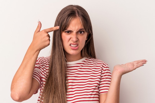 Jonge kaukasische vrouw die op witte achtergrond wordt geïsoleerd die een teleurstellingsgebaar met wijsvinger toont.