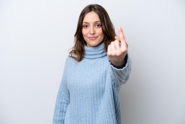 Jonge kaukasische vrouw die op witte achtergrond wordt geïsoleerd die komend gebaar doet