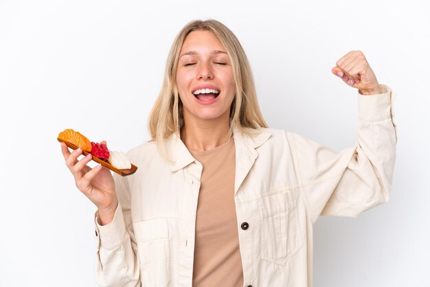 Jonge kaukasische vrouw die sashimi houdt die op witte achtergrond wordt geïsoleerd en sterk gebaar doet