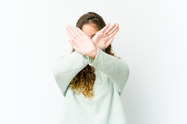 Jonge kaukasische vrouw die twee gekruiste wapens houdt, ontkenningsconcept.