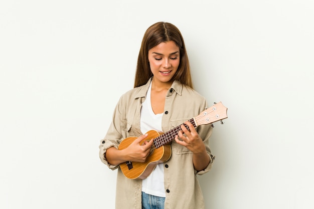 Jonge Kaukasische vrouw die ukelele speelt