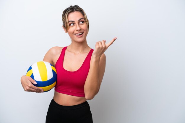 Jonge kaukasische vrouw die volleybal speelt geïsoleerd op een witte achtergrond die van plan is de oplossing te realiseren terwijl ze een vinger opheft