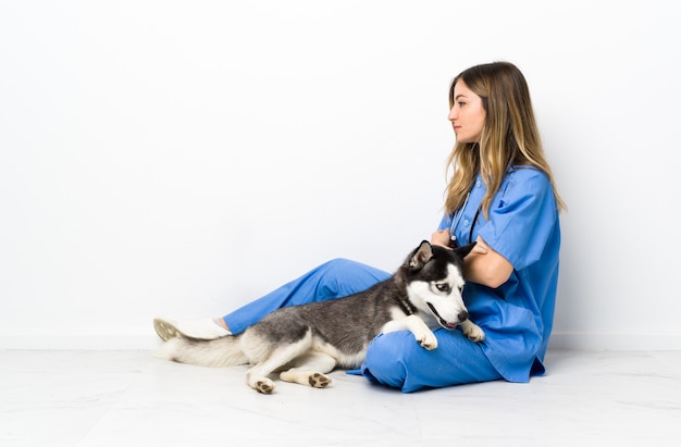 Jonge Kaukasische vrouw met hond over geïsoleerde muur