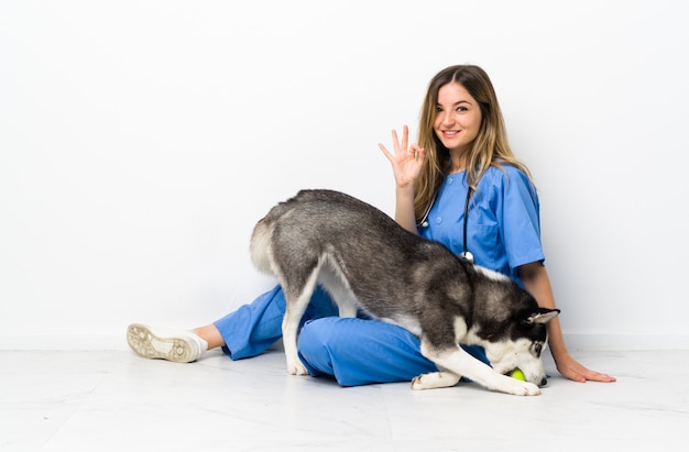 Jonge Kaukasische vrouw met hond over geïsoleerde muur