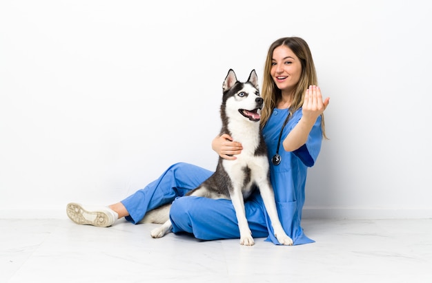 Jonge Kaukasische vrouw met hond over geïsoleerde muur