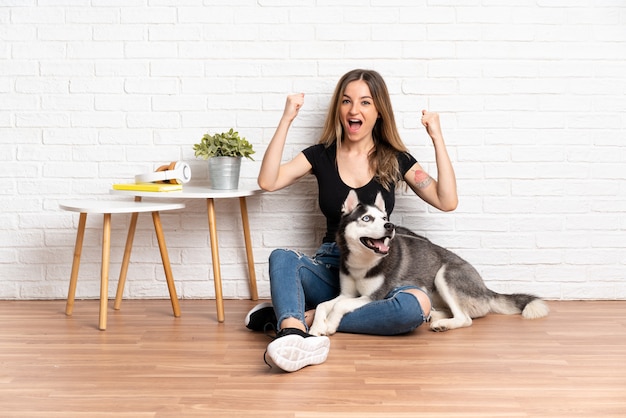 Jonge kaukasische vrouw met hond over geïsoleerde muur