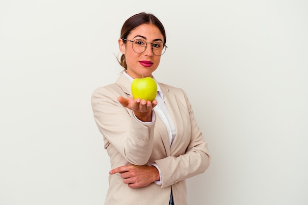 Jonge kaukasische zakenvrouw die een geïsoleerde appel eet