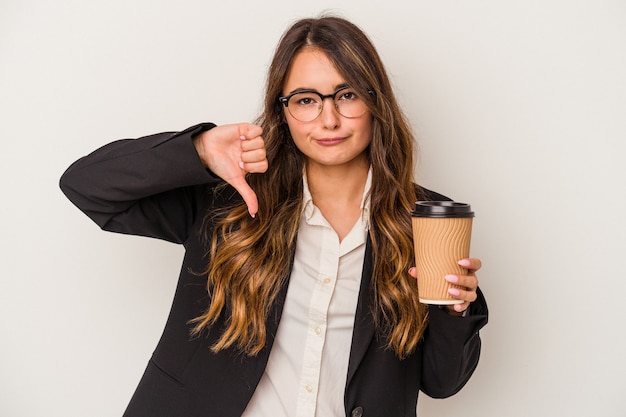 Jonge Kaukasische zakenvrouw met een afhaalmaaltijden koffie geïsoleerd op een witte achtergrond met een afkeer gebaar, duim omlaag. Onenigheid begrip.