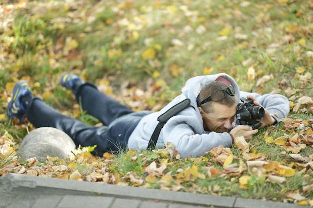 Foto jonge kerel die foto's maakt in het herfstpark