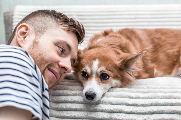 Jonge kerel en hond. Close-up portret. Rode hond en rode man