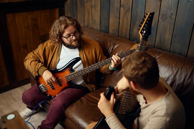 Jonge kerel luistert terwijl gitarist muziek speelt