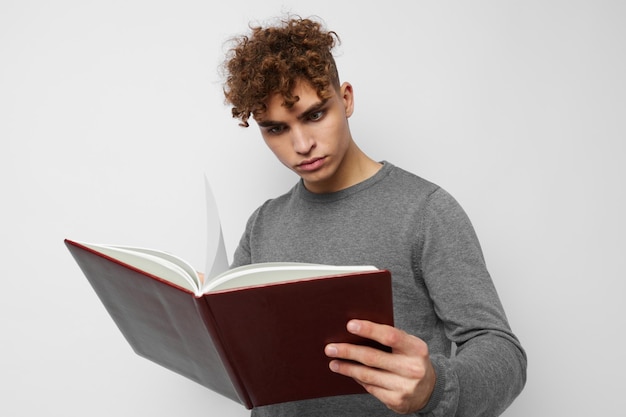 Jonge kerel met boek leren onderwijs poseren