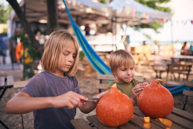 Jonge kinderen snijden Halloween-pompoen
