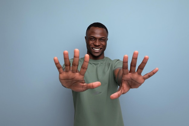 jonge knappe Afrikaanse man gekleed in T-shirt toont ontkenning en onenigheid met handen