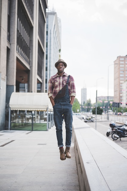 jonge knappe afro zwarte man springen froma kleine muur buiten in de stad
