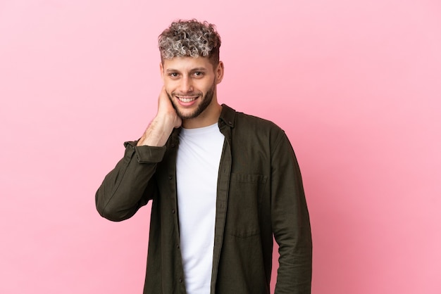 Jonge knappe blanke man geïsoleerd op roze achtergrond lachen