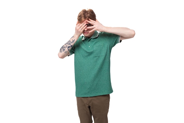 Jonge knappe blanke roodharige man gekleed in een groen T-shirt heeft twijfels en nadenkt