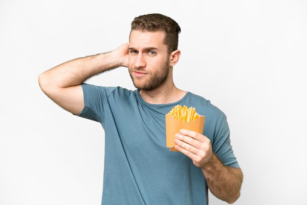 Jonge knappe blonde man met gebakken chips over een geïsoleerde witte achtergrond met twijfels