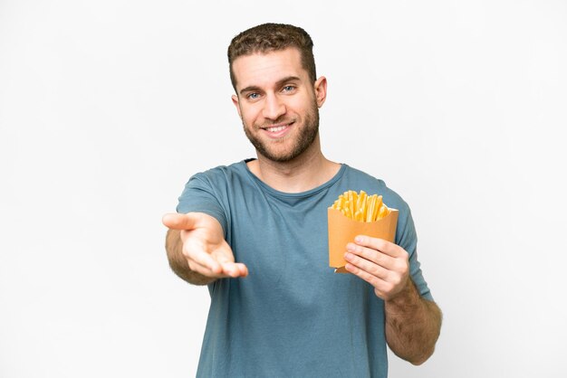 Jonge knappe blonde man met gebakken chips over geïsoleerde witte achtergrond handen schudden voor het sluiten van een goede deal