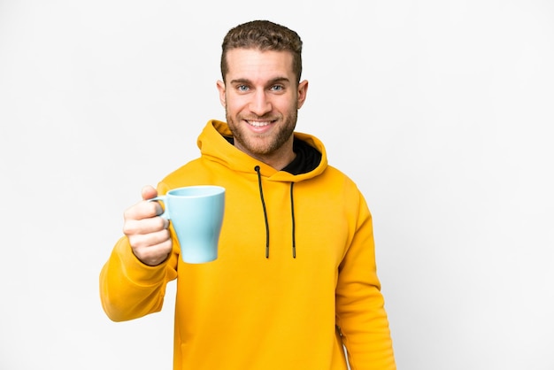 Jonge knappe blonde man met kopje koffie over geïsoleerde achtergrond met gelukkige uitdrukking