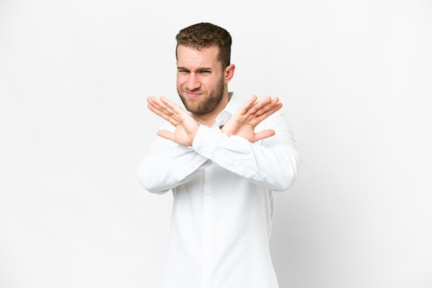 Jonge knappe blonde man over geïsoleerde witte achtergrond nerveus uitstrekt handen naar voren