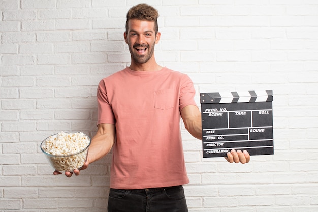 Jonge knappe cool man met popcorns. film- of filmconcept