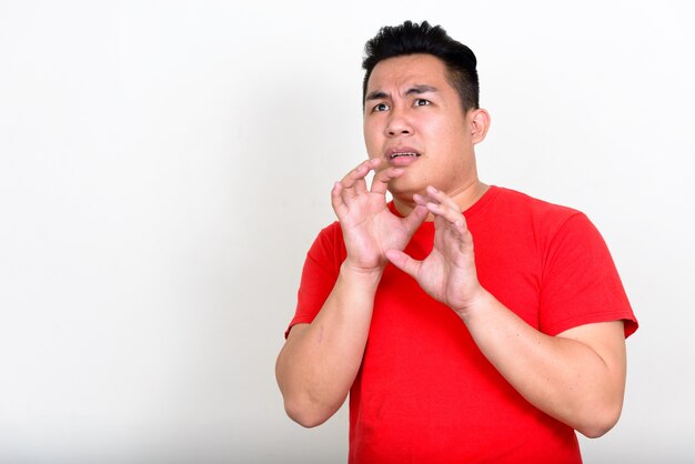 jonge knappe Filipijnse man met overgewicht tegen een witte muur