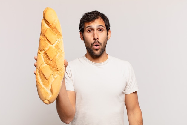 Jonge knappe Indiase man bang uitdrukking en met een brood