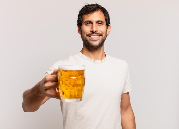 Jonge knappe Indiase man gelukkige uitdrukking en met een biertje