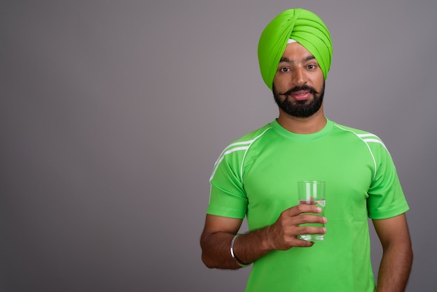 Jonge knappe Indiase Sikh man met tulband en groen shirt
