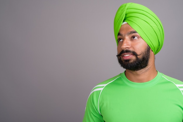 Jonge knappe Indiase Sikh man met tulband en groen shirt