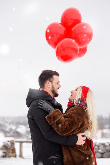 Jonge knappe jongen en meisje met een ballonnen lopen op Valentijnsdag