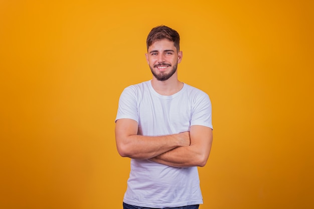 Jonge knappe jongen glimlachend camera kijken met gekruiste armen.