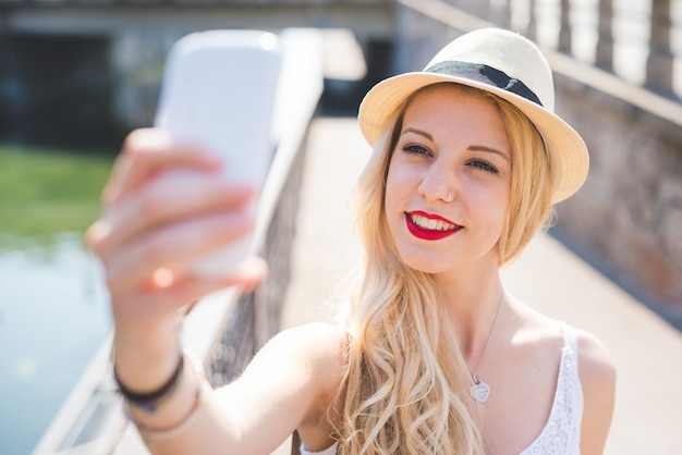 jonge knappe Kaukasische lange blonde rechte haarvrouw die technologische apparaten gebruiken