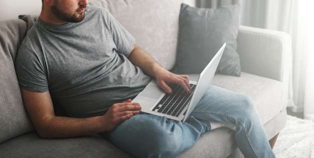 Jonge knappe man aan het werk op zijn laptop